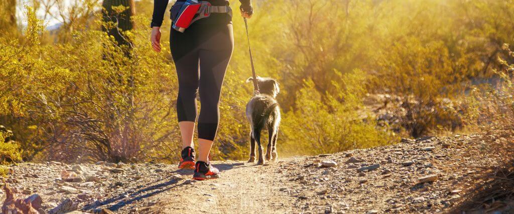 A woman walking her dog outside in Arizona